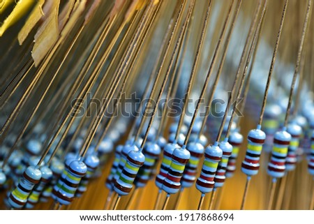 Artistically arranged new resistors of the same rating with a power of 0.25 watts in their original packaging. The picture was taken with a shallow depth of field.