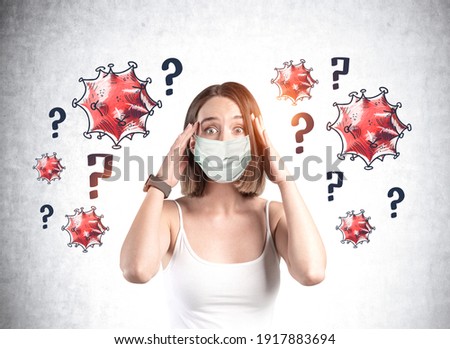 Woman wearing face mask because of coronavirus, covid-19, pandemic in the world and holding her head because of stress. Sketched virus over question marks. Looking for a reason of corona spread.
