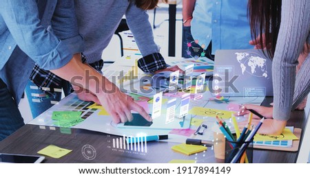Close up ux developer and ui designer use augmented reality app brainstorming about mobile interface wireframe design on desk at modern office.Creative digital development agency Royalty-Free Stock Photo #1917894149