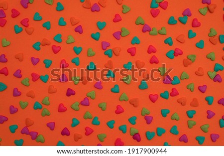  Colorful heart shape sweet candy on bright orange background. Happy birthday greeting card. Holiday background. Sweet candy concept. Minimal concept.                                              
