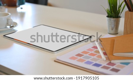 Cropped shot of blank screen mock up tablet and office supplies in designer workspace