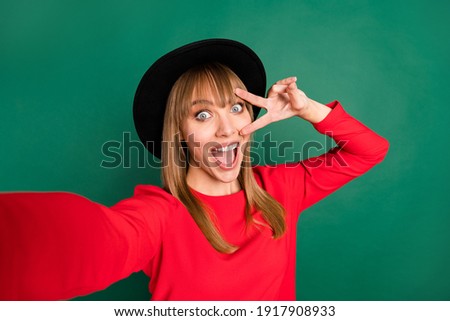 Photo of young happy excited crazy funky funny pretty girl taking selfie show v-sign on eye isolated on green color background