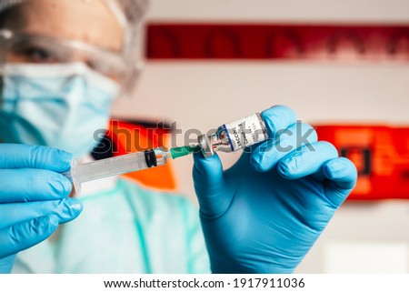 COVID-19 vaccine in researcher hands, female doctor holds syringe and bottle with vaccine for coronavirus cure. Concept of corona virus treatment, injection, shot and clinical trial during pandemic.