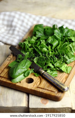 Selective focus. Fresh chopped spinach on a wooden board. Royalty-Free Stock Photo #1917925850