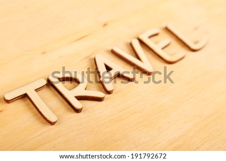 Closeup on wooden background wooden text "Travel"