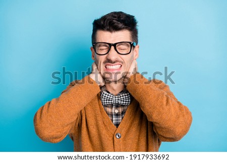 Photo of young man unhappy sad upset hands touch neck pain suffer injury isolated over blue color background