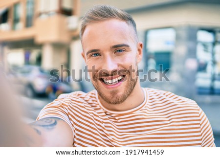 Young irish man smiling happy making selfie by the camera at street of city.
