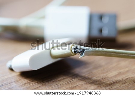 broken and frayed cable  charger for smart phones Royalty-Free Stock Photo #1917948368