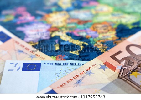 Euro banknotes on the Europe map. Concept of Eurozone, European economy, stock market in EU Royalty-Free Stock Photo #1917955763