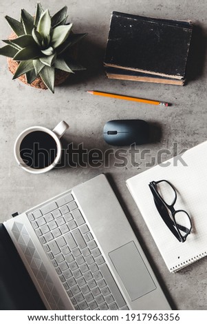 laptop and book, coffee on gray background, Top view of office desk on textured gray background