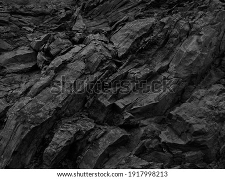     Black white rock basalt background. Dark gray stone texture. Mountain surface close-up. Distressed, сracked, collapsed, crumbled, broken.	                       Royalty-Free Stock Photo #1917998213