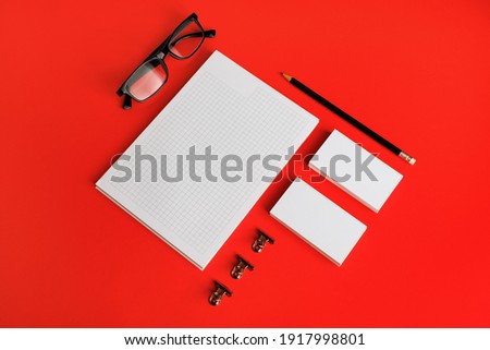 Photo of blank stationery set on red paper background. Corporate identity mockup. Responsive design template.