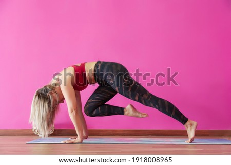 Blonde woman doing yoga, background pink and copy space