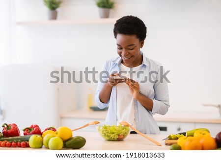 Food Blogging. Black Female Blogger Taking Photo Of Healthy Dinner On Phone Cooking Salad Standing In Modern Kitchen At Home. Nutrition And Weight Loss Blog Concept. Dieting And Slimming App