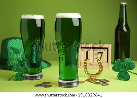Beer, gold and St Patrick's Day decor on green background