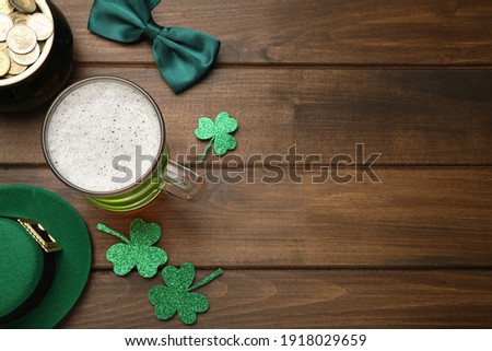Beer, gold and St Patrick's Day decor on wooden table, flat lay. Space for text
