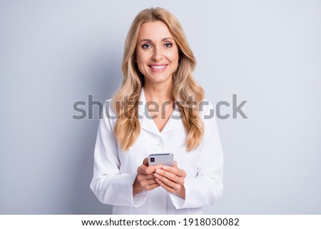 Photo of positive attractive lady hands hold phone toothy smile look camera isolated on grey color background