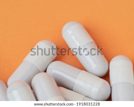 White medical pills and pills spilling out of a medicine bottle. A top-down macro with space to copy.       