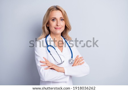 Photo of sweet confident mature lady doctor wear white coat arms crossed empty space isolated grey color background Royalty-Free Stock Photo #1918036262