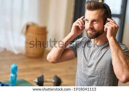 Bearded young man listening to music at home