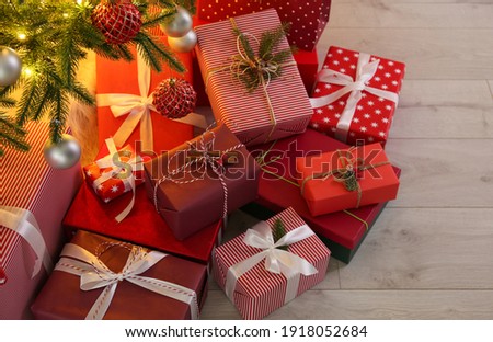 Pile of gift boxes near Christmas tree on floor Royalty-Free Stock Photo #1918052684