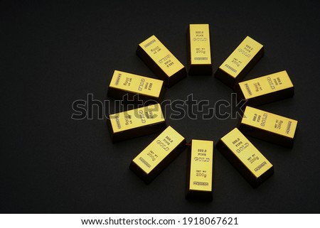 Scattered gold bars on the black table. Shiny precious metals for investments or reserves. Bank image and photo.