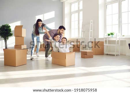 Family with children having fun in new home. Joyful first-time buyers with kids playing with boxes in living room. Real estate, residential mortgage, moving into dream house, happy future concept Royalty-Free Stock Photo #1918075958