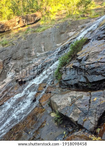 A close up picture of waterfall, showing fresh water from the top of the mountain, flow down to the earth and create a river. 