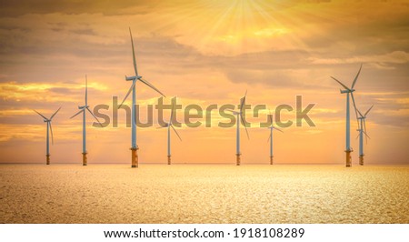 Offshore Wind Turbine in a Windfarm under construction off the England Coast at sunset Royalty-Free Stock Photo #1918108289