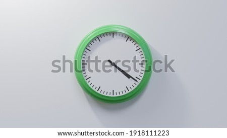 Glossy green clock on a white wall at twenty-one past four. Time is 04:21 or 16:21 Royalty-Free Stock Photo #1918111223