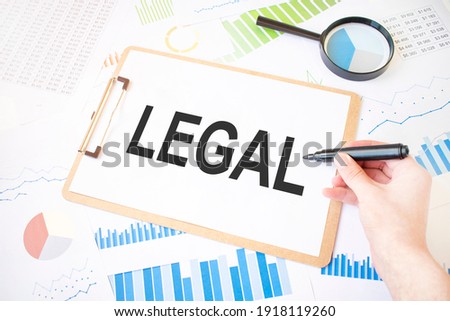 Text LEGAL on white paper sheet and marker on businessman hand on the diagram. Business concept