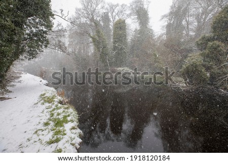 river, stream, during a snow storm, blizzard, in winter in scotland.