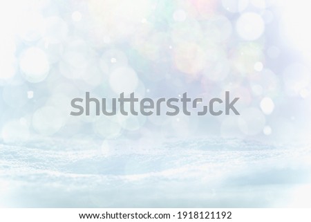 SNOW AND BOKEH LIGHTS BACKGROUND, BLUE ICE AND SNOW COVER BACKDROP WITH SNOW FLAKES FALLING AND SOFT COLORFUL CIRCLE LIGHT PATTERN