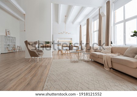 interior design spacious bright studio apartment in Scandinavian style and warm pastel white and beige colors. trendy furniture in the living area and modern details in the kitchen area. Royalty-Free Stock Photo #1918121552