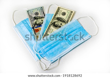 concept business and coronavirus hygiene masks and hundred dollar bills fanned out. High quality photo