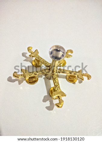 A miniature asymmetrical dagger known as Keris with white background. All the miniature are lay down to white surface perform a star shape. Subject focus on center of star of miniature.