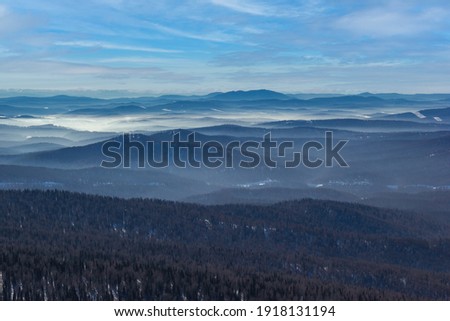 Wonderful winter mountains landscape on a sunny day. Mountains in the distance in fog.