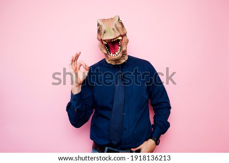 Man with euphoric dinosaur head and fingers with ok symbol