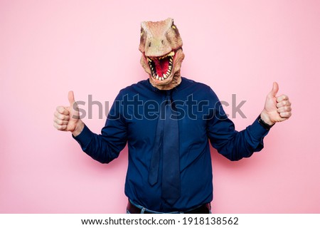 Man with euphoric dinosaur head and fingers up