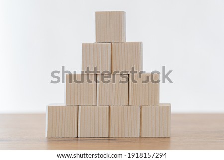 Businessman hand arranging wood blocks in a step stair concept.  Concept for growth, strategy, success process or investment goals.