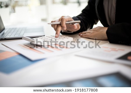 The company's finance manager is using a calculator, he uses a calculator to calculate the numbers in the company's financial documents that employees in the department create as meeting documents. Royalty-Free Stock Photo #1918177808