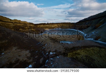 canyon on a background of blue sky and frozen water with dry grass in winter 