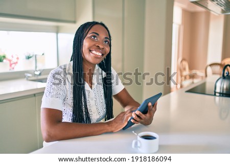 Young african american woman smiling happy using touchpad at home
