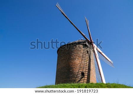 The old brick windmill on top of the hill in Holland on a beautiful spring day.