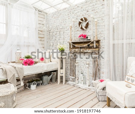 A whimsical shabby chic vintage Garden bedroom. Light interior with a pop of pink. Repurposed salvaged faux fireplace, candles, and cozy vintage bed with layered pillows perfect for an afternoon nap.  Royalty-Free Stock Photo #1918197746