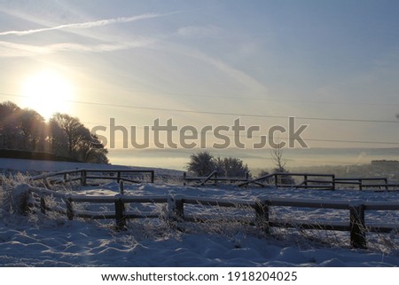 sunrise over a snowy setting. landscape picture with mist over the valley in the distance