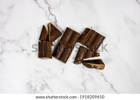 quality chocolate on white marble bottom tablet into pieces
