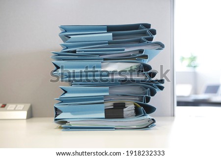 Stack of file folders with documents on a desk in the office