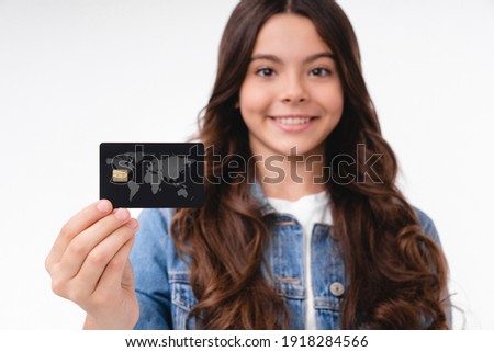 Close up photo of a teenage girl holding focused credit card isolated over white background