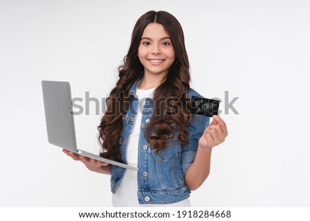Cheerful young caucasian girl holding laptop with credit card isolated over white background